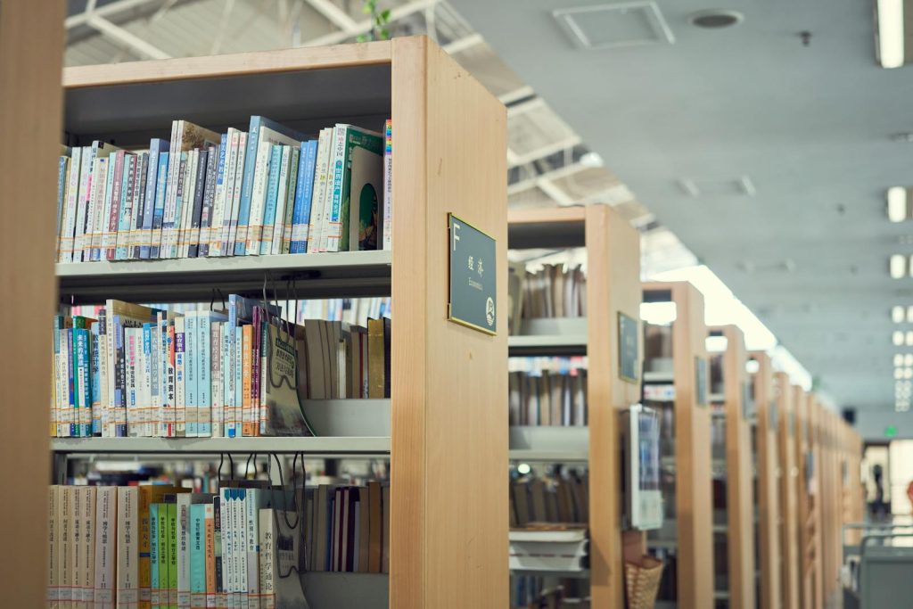 A well-organized library with rows of bookshelves and books in a cozy, quiet environment.