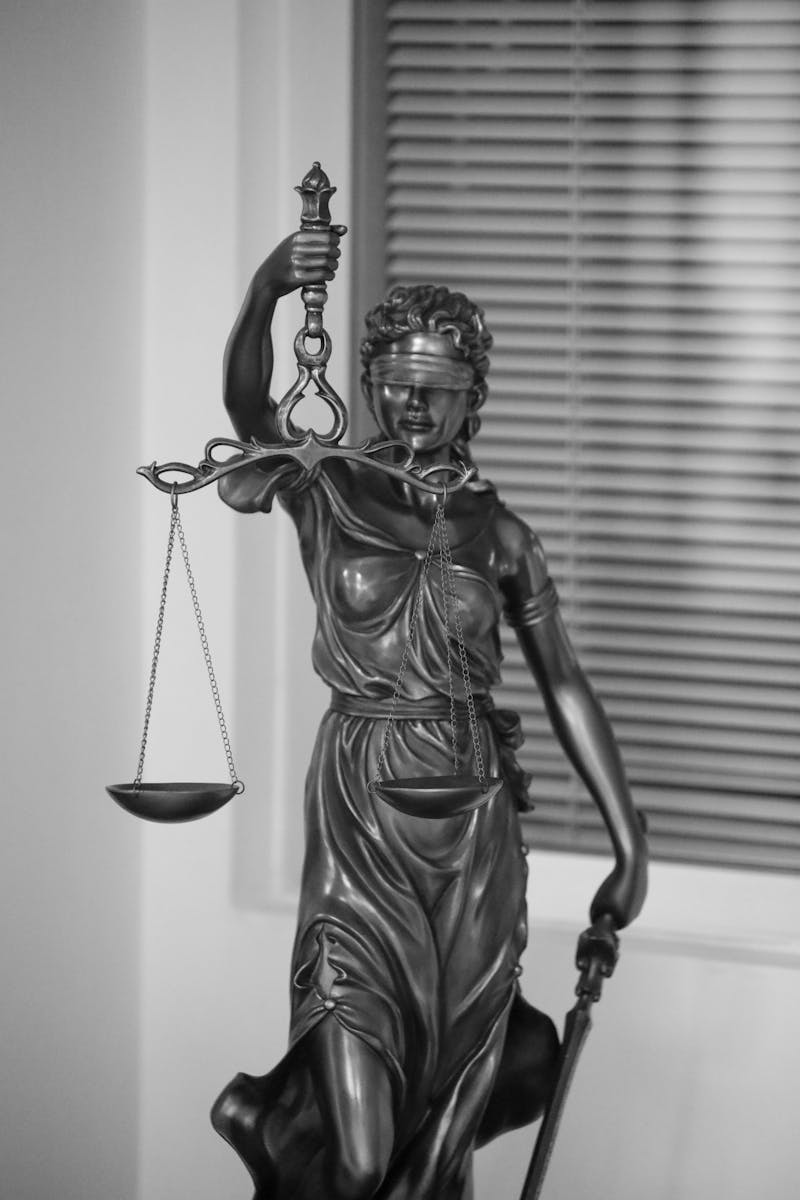 Elegant black and white photo of Lady Justice statue, symbolizing fairness and law.